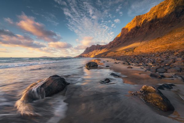 The long Playa de Famara on Lanzarote in the warm light of the sunset