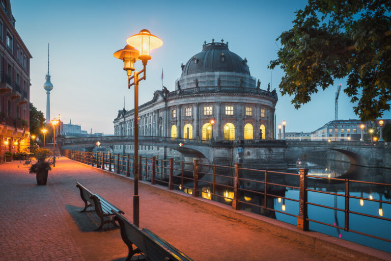 Die Museumsinsel in Berlin in schönem Morgenlicht mit dem Bode Museum und dem Fernsehturm. Promenade mit schönen Lampen und Bänken.