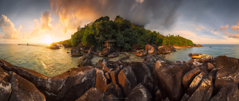 Ein verlassenes Resort mit decaying Holzhütten an der Küste der Insel Pulau Tioman / Malaysien im warmen Licht der tropischen Sonne spät am Tag. Panorama.